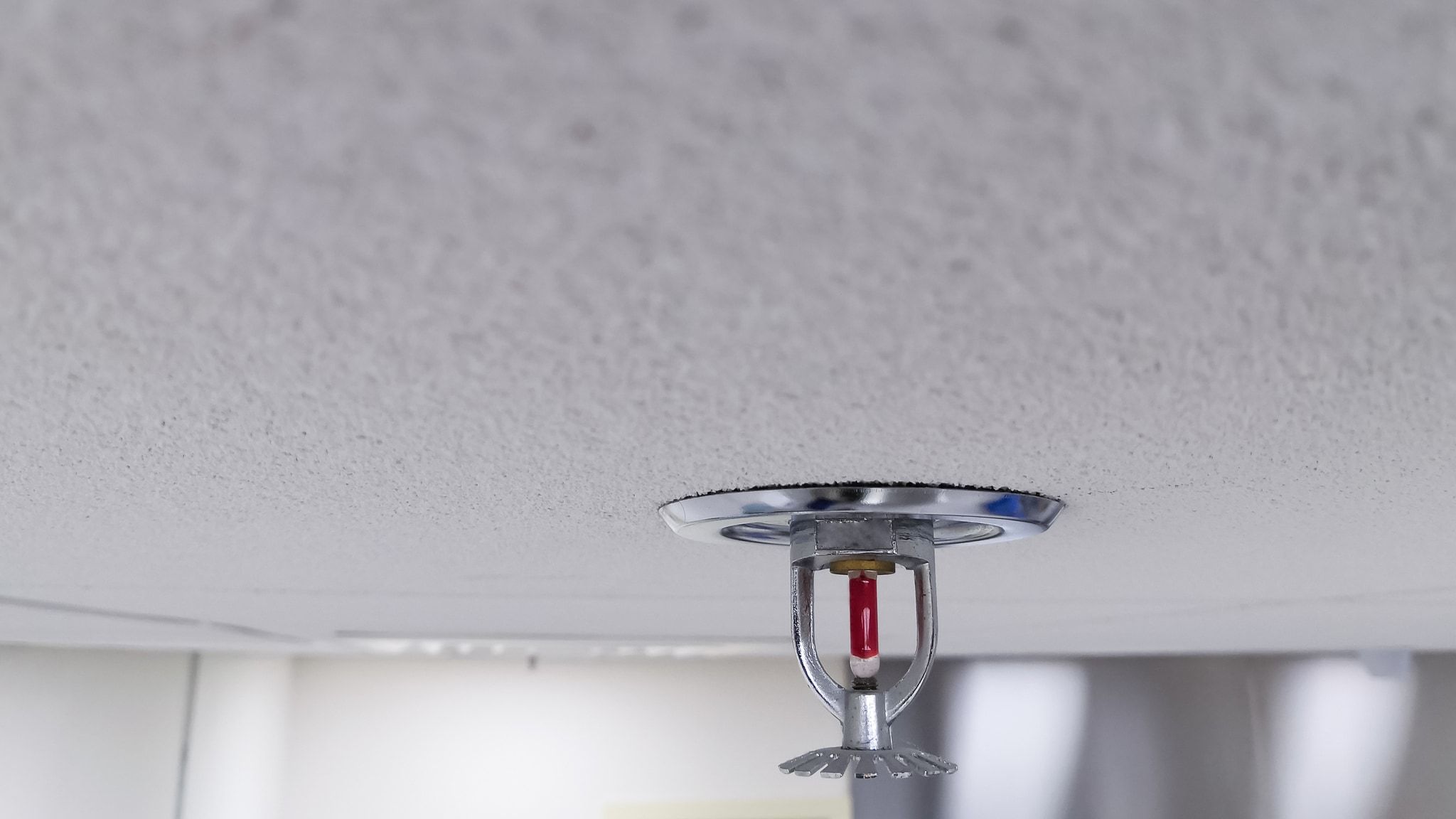 Rociador automático tipo sprinkler instalado en el techo de una nave industrial conforme a UNE-EN 12845
