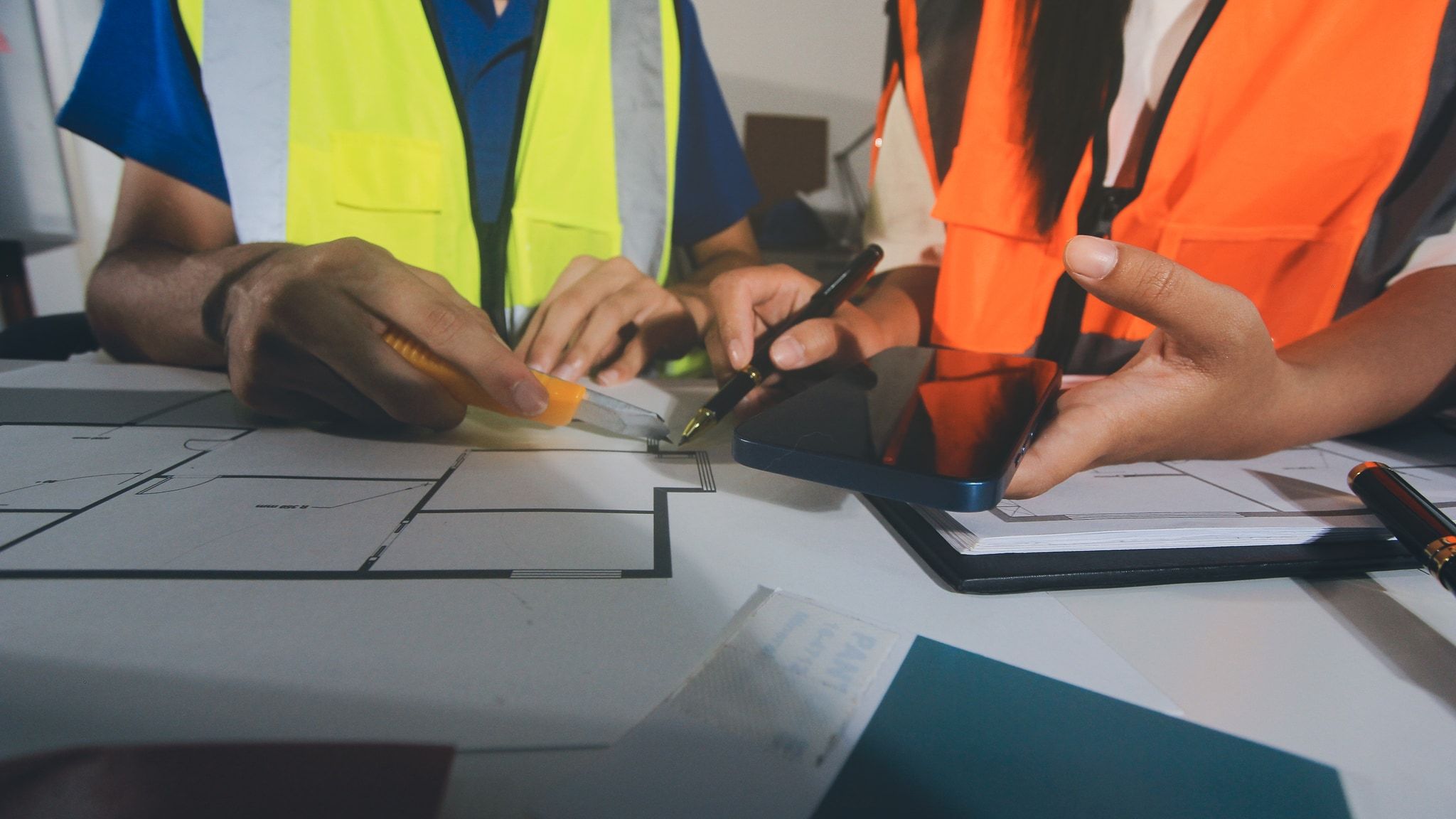 Equipo de ingenieros industriales en reunión revisando planos y procedimientos de emergencia